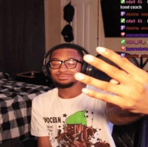 a man wearing headphones and a shirt that says ocean holds up his fingers
