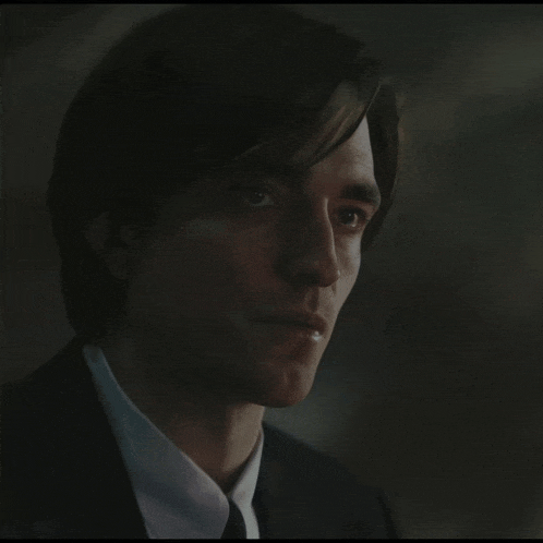 a close up of a man 's face with a suit and tie