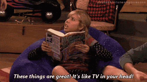 a girl sits on a bean bag chair reading a book and says these things are great