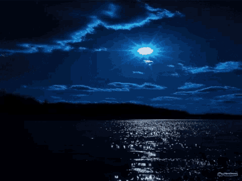 a full moon shines brightly over a lake at night