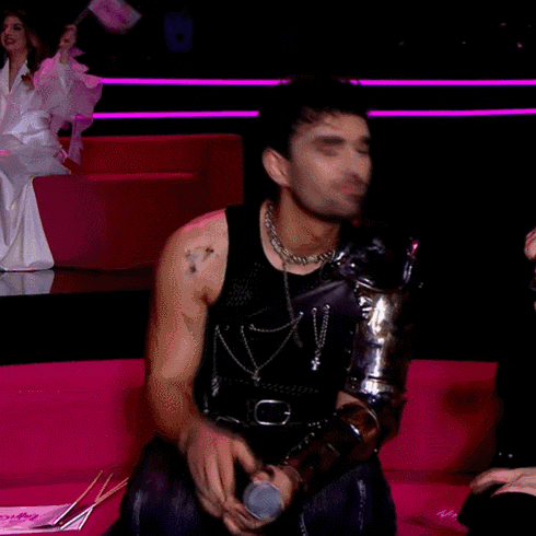 a man sitting on a couch with a microphone in his hand