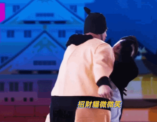 a man in a cat costume is hugging another man in front of a building