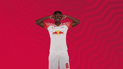 a man wearing a red bull shirt with the number 8 on the shorts