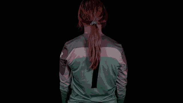 a woman is wearing a green jersey with the number 1 on the back