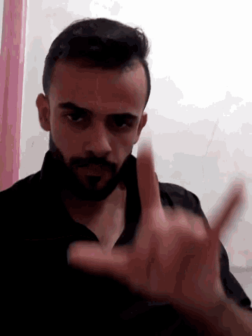 a man with a beard is making a hand gesture with his fingers