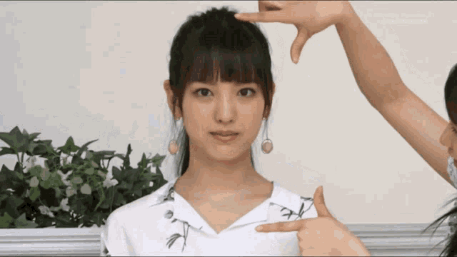 a woman in a white shirt is being measured by another woman 's hand