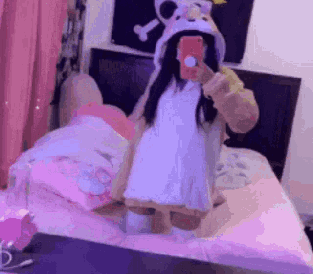a girl is taking a selfie in front of a mirror while wearing a bunny costume .