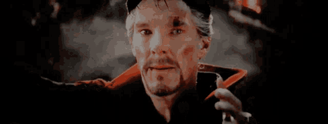 a close up of a man 's face with a beard pointing up with his finger .