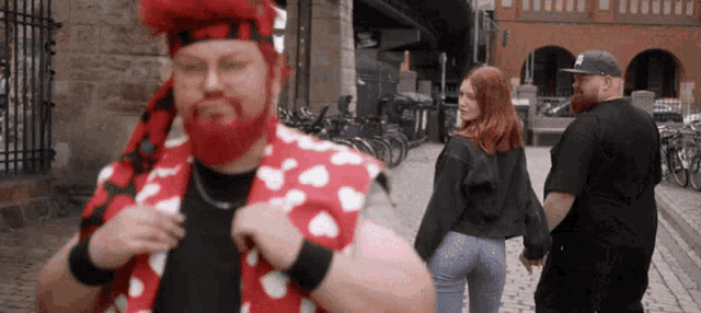 a man with a red beard is wearing a red and white heart shirt