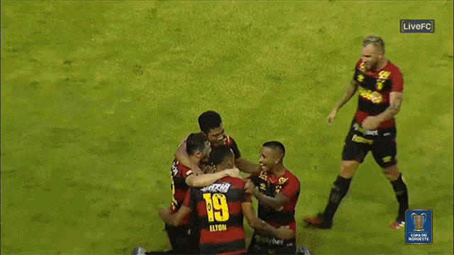 a soccer player with the number 19 on his jersey is hugging his teammates