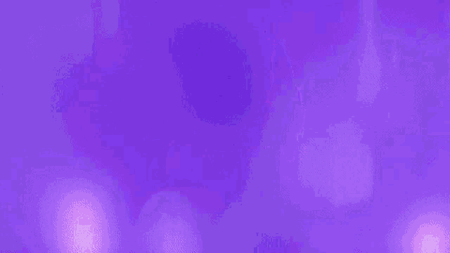 a woman in a fur coat is dancing in a purple room with purple lights .