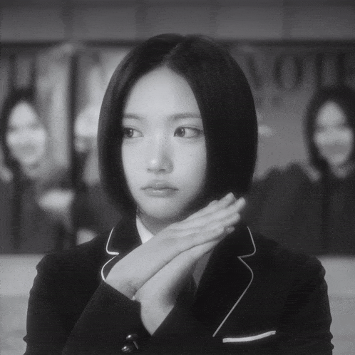 a black and white photo of a girl with a sign in the background that says no