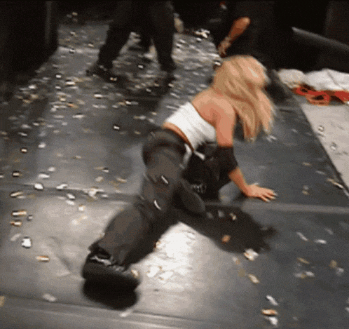 a woman in a white tank top and black pants is kneeling on the floor
