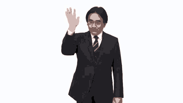 a man in a suit and tie is waving his hand in the air .