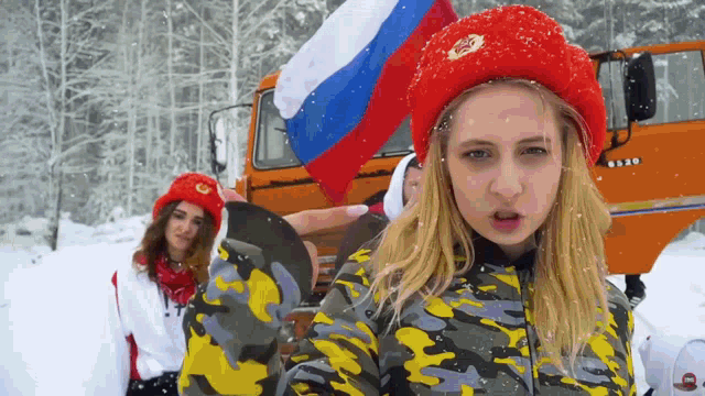 a woman in a red hat holds a russian flag in her hand