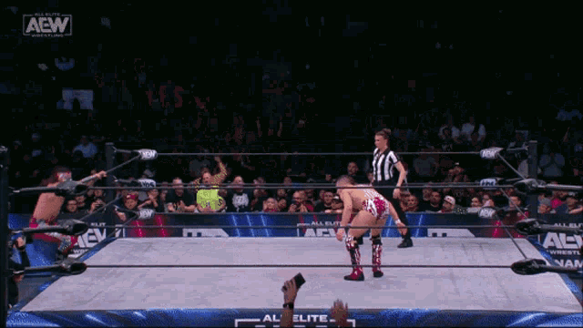 a wrestler in a ring with a aew logo
