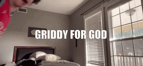 a room with a bed and a window with the words griddy for god above it