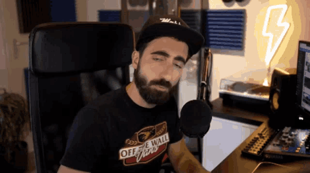 a man with a beard wearing an off the wall vans shirt