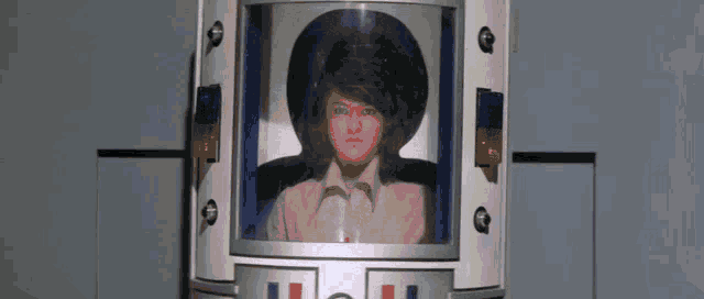 a woman in a hat is sitting in a capsule with the letter l on it