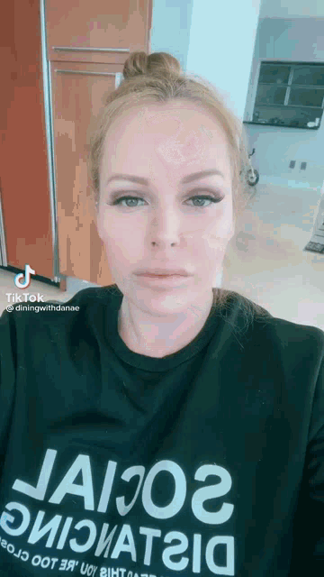 a woman wearing a black t-shirt with the word jaio2 on it .
