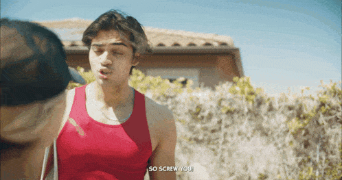 a man in a red tank top says " so screw you " to another man