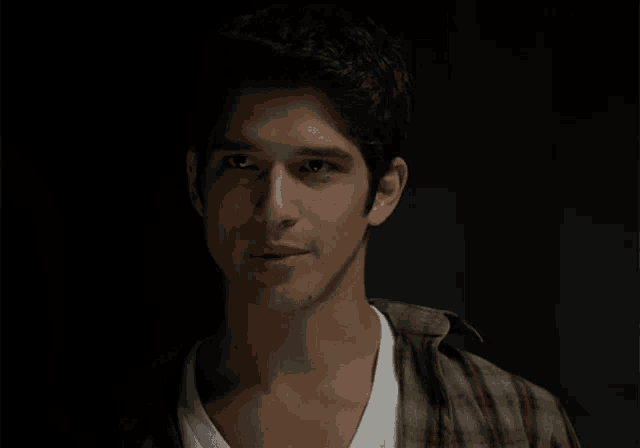 a close up of a young man 's face with a dark background