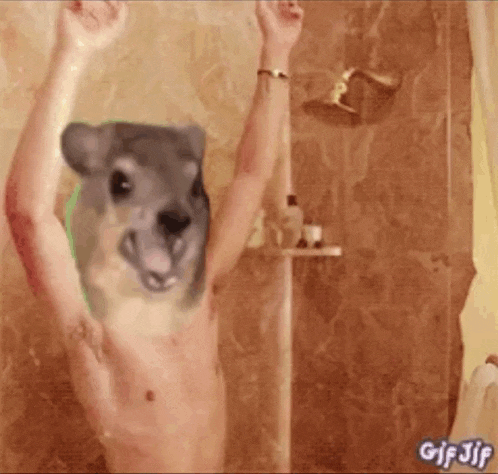 a shirtless man is taking a shower with a picture of a dog on his head .