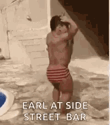 a shirtless man in striped swim trunks is standing next to another man .