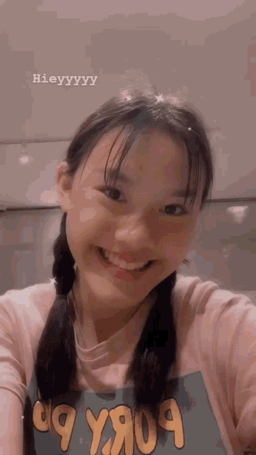 a girl with pigtails is smiling and wearing a t-shirt that says 99 y9o9