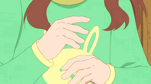 a girl with brown hair is wearing a green shirt with a yellow letter l on it