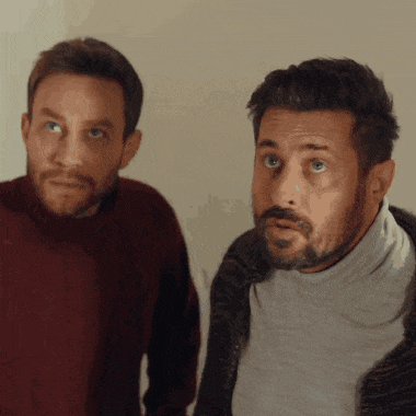 two men are standing next to each other and one is wearing a turtleneck
