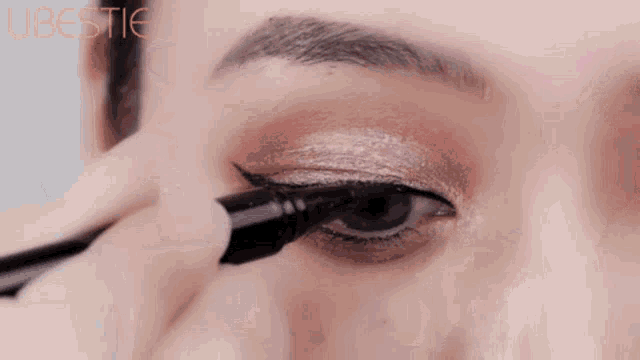 a close up of a woman applying eyeliner with the word libestie visible in the corner