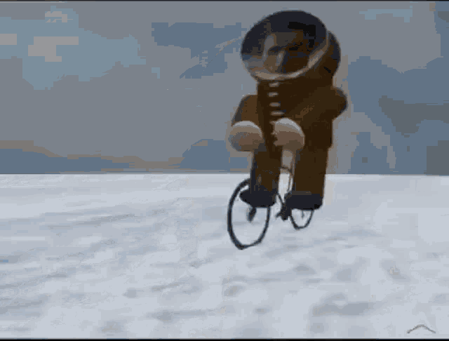 a man in a space suit is riding a bicycle on a snowy surface .