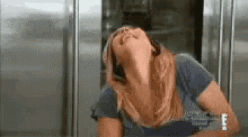 a woman is standing in front of a refrigerator with her head up and her eyes closed .