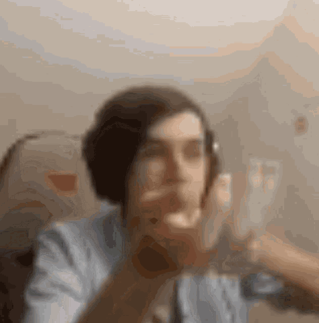a blurry picture of a man wearing headphones and a blue shirt