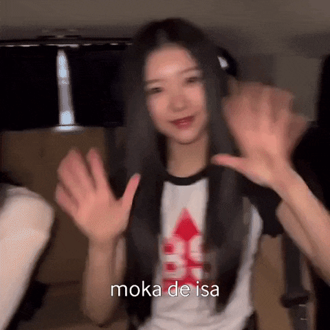 a woman with long black hair is waving her hands in a car .