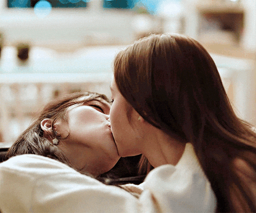a couple of women kissing each other with their eyes closed