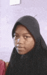 a close up of a woman wearing a black hijab .