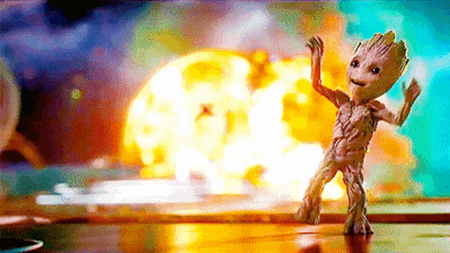 groot from guardians of the galaxy 2 is dancing in front of a giant explosion .