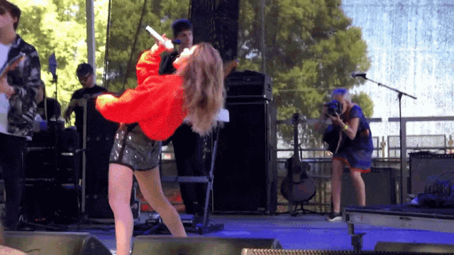 a woman singing into a microphone on stage
