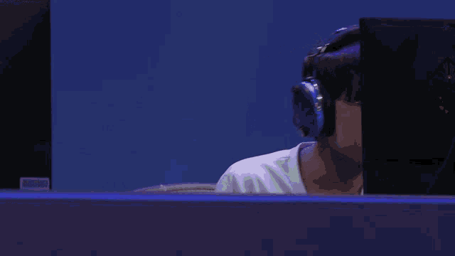 a man wearing headphones is looking at a computer screen