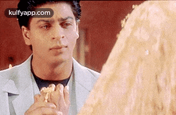 a man is looking at a woman while holding a piece of cake .