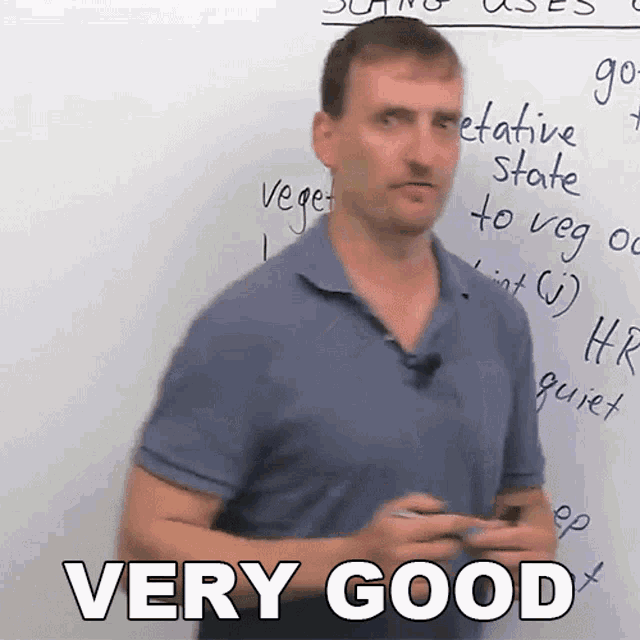 a man is standing in front of a white board with the words very good written on it