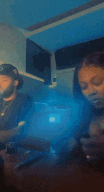 a man and a woman are sitting at a table with smoke coming out of them