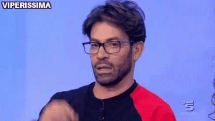 a man with glasses and a beard is making a funny face on a television show .