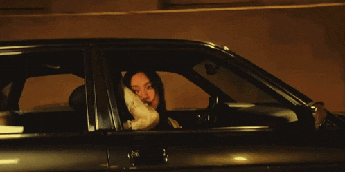a woman sitting in a car with her hand on her face