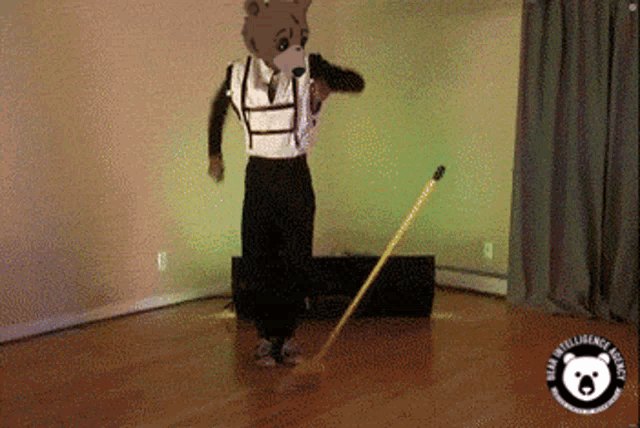 a man in a bear costume is sweeping the floor with a mop