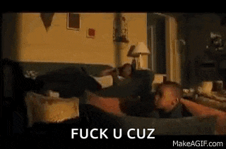 a man and a child are sitting on a couch in a living room with the words `` fuck u cuz '' above them .