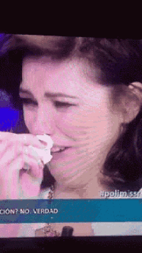a woman is crying while holding a napkin to her nose