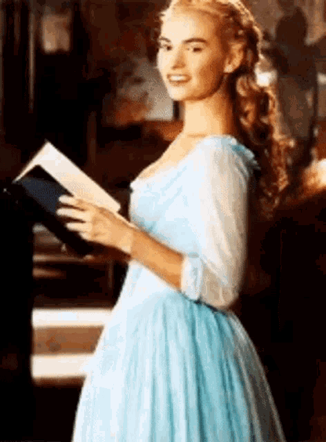 a woman in a blue dress is reading a book .